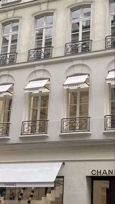 the storefront of chanel is decorated with white awnings and black iron balconies