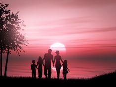 a family standing in front of a sunset on the water with their hands together and looking out at the ocean