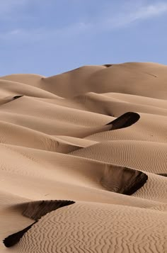 the sky is blue and there are many sand dunes