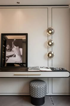 a white table topped with a mirror next to a black and white footstool