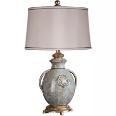 a table lamp with a white shade on it and a silver base, sitting next to a