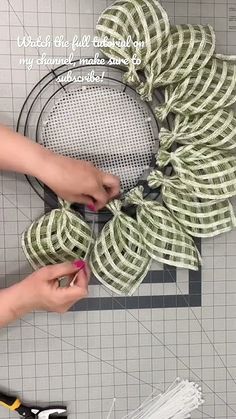 someone is making a wreath out of dollar bills with scissors and thread on the table