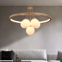 a living room filled with white furniture and lights hanging from it's ceiling fixture