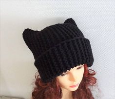 a mannequin head wearing a black knitted cat hat