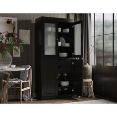 a black cabinet with glass doors in a dining room area next to a table and chairs