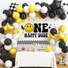 a table topped with balloons and stars next to a sign that says one happy dude