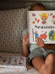 a child is reading a book on the bed