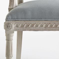 an upholstered chair with a blue cushion on it's back and sides