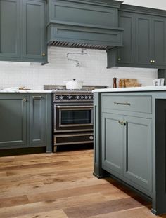 a kitchen with gray cabinets and wood floors