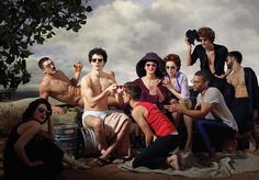 a group of people sitting on top of a beach next to each other holding drinks