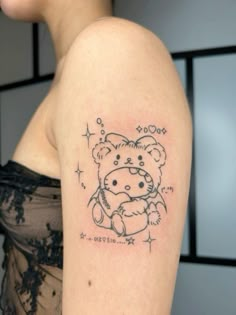 a woman with a tattoo on her arm that has a teddy bear holding a star