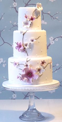 a three tiered cake with flowers painted on it