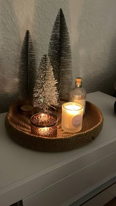 a candle is sitting on a tray with christmas trees in the middle and candles around it