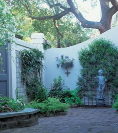 an outdoor courtyard with stone steps and plants growing on the walls, along with a statue