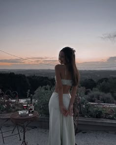 a woman standing on top of a roof next to a table