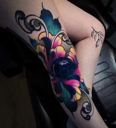 a woman's legs with tattoos on them and flowers in the middle of her leg