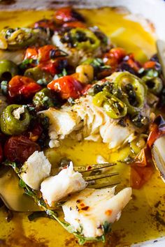 a white plate topped with fish and veggies on top of yellow food coloring