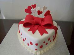 a heart shaped cake decorated with red and white hearts