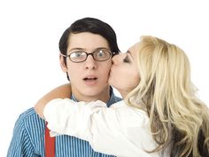 a man and woman kissing each other in front of a white background