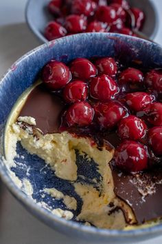 a bowl filled with chocolate and cherries on top of a table