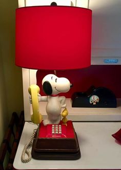 a lamp that is sitting on top of a desk next to a phone and telephone