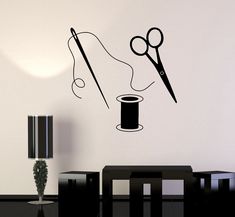 a wall decal with scissors and thread on it