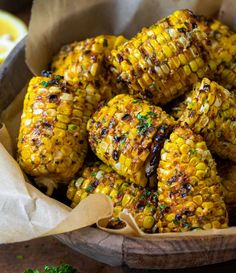 grilled corn on the cob in a wooden bowl