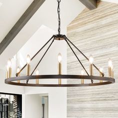 a large chandelier hanging from the ceiling in a room with white walls and wood beams