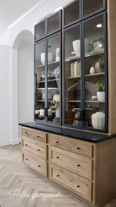 a wooden cabinet with glass doors and drawers