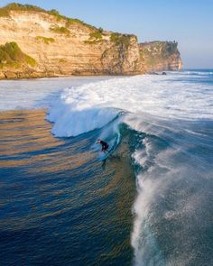 a man riding a wave on top of a surfboard