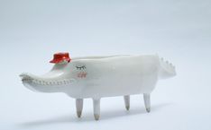 a white ceramic animal with a red hat on it's head