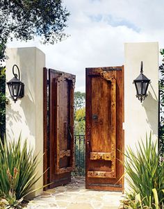 two wooden doors open in front of a white building