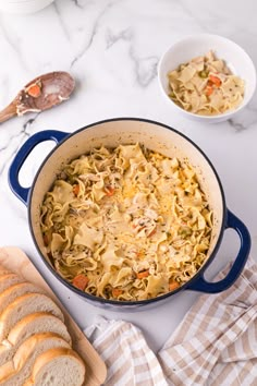 a pot filled with pasta and bread on top of a table