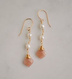 "Genuine Sunstone & Freshwater Pearl Earrings - Sterling Silver or 14k Gold Filled Classic elegance. These lightweight earrings are handmade with white freshwater pearls and natural peach Sunstone.  First discovered in Norway, Sunstone gets its shimmering nature from tiny pieces of Hematite. It is believed that this gem carries the uplifting energy of the sun, and is perfect for those who are stuck in a rut or need a little reminder to live and enjoy life. It is a stone of empowerment that helps Pearl Dangle Earrings, Freshwater Pearls Earrings, Peach Moonstone, White Freshwater Pearl, Lightweight Earrings, Pearl Earrings Dangle, Light Weight Earrings, Matching Necklaces, Classic Elegance