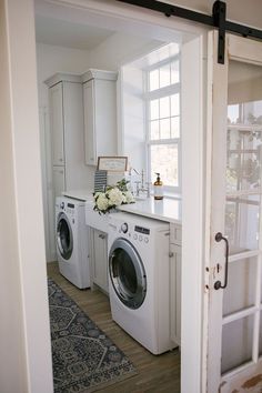 a washer and dryer in a room with an open door to another room