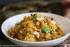 a white bowl filled with rice and nuts on top of a cloth covered tablecloth