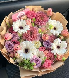 a bouquet of flowers sitting on the dashboard of a car