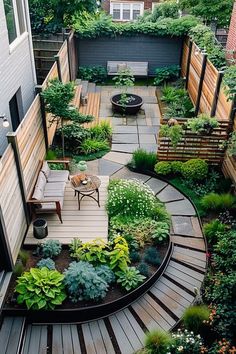 an outdoor garden with lots of plants and seating area in the back yard, surrounded by wooden