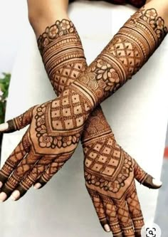 two hands with henna tattoos on them