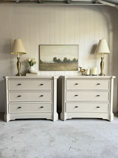 two white dressers sitting next to each other in a room