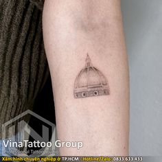 a small tattoo on the arm of a woman's left arm, with an image of a dome