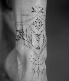 a black and white photo of a woman's foot with an intricate design on it