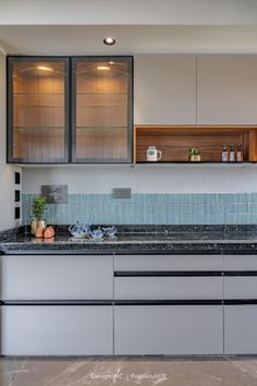 a kitchen with marble counter tops and stainless steel appliances, along with glass cabinet doors