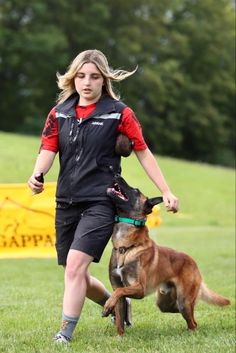 a woman is playing frisbee with her dog