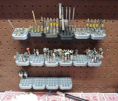 there are many different tools on the pegboard