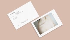 two white business cards with an image of a woman's torso on one side