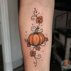 an orange pumpkin with vines and leaves tattoo on the left calf side ribcage