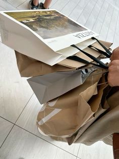 a person is holding several bags with papers on them