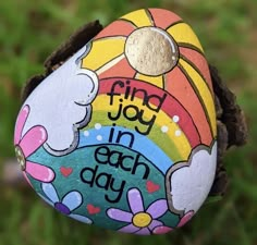 a painted rock that says find joy in each day