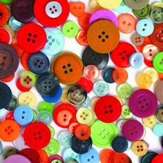 many different colored buttons on a white surface